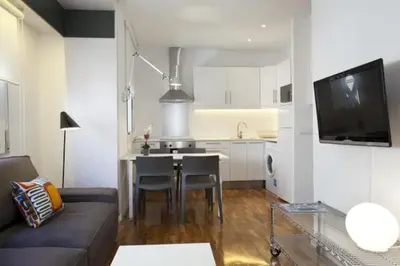 a living room with a couch and a kitchen with a table at Barceloneta near Beach Apartments in Barcelona
