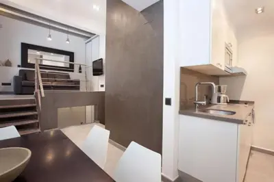 a kitchen and living room with a sink and a table at Barceloneta Apartment in Barcelona