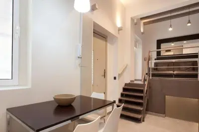 a dining room with a black table and white chairs at Barceloneta Apartment in Barcelona