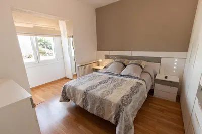a bedroom with a large bed and a window at Catalunya Casas Cozy beach town villa for 8 - no car necessary! in Pineda de Mar