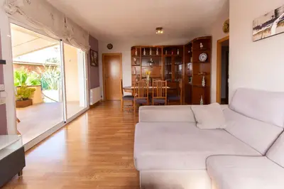a living room with a white couch and a dining room at Catalunya Casas Cozy beach town villa for 8 - no car necessary! in Pineda de Mar