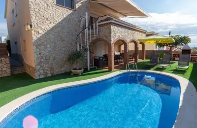 a swimming pool in front of a house at Catalunya Casas Cozy beach town villa for 8 - no car necessary! in Pineda de Mar