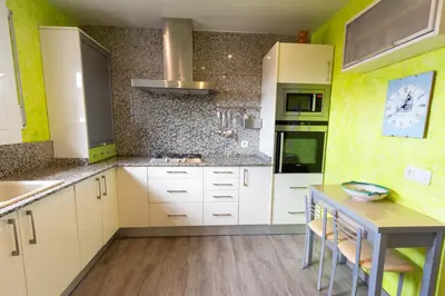 a kitchen with white cabinets and a clock on the wall at Catalunya Casas Cozy beach town villa for 8 - no car necessary! in Pineda de Mar