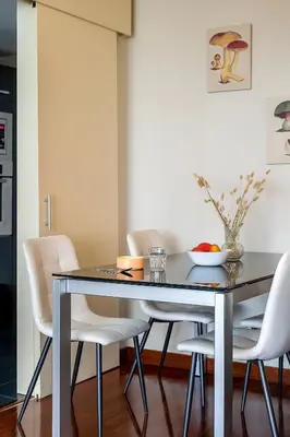 a dining room table with white chairs and a bowl of fruit on it at Canela Homes BARCELONA FÒRUM in Sant Adria de Besos