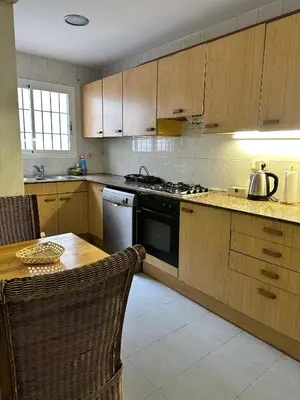 a kitchen with wooden cabinets and a table and a stove at Relax Holiday Home in Vallromanas