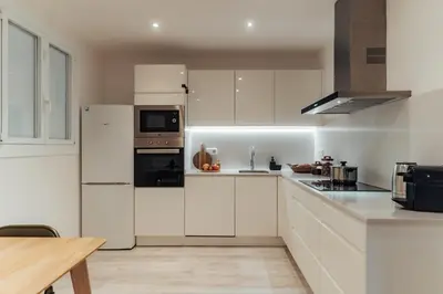 a white kitchen with white cabinets and appliances at Casa Central in Barcelona