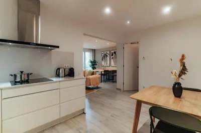 a kitchen with white cabinets and a wooden table at Casa Central in Barcelona