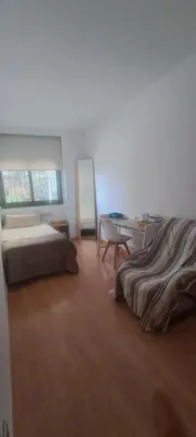 a bedroom with a bed and a desk and a table at Lovely Room near Park Guell in Barcelona