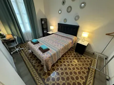a small bedroom with a bed and two lamps at Alojamiento Rogeretto in Barcelona