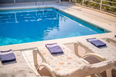 two lounge chairs and a swimming pool at Villa Sitges Cambera 10 minutos de Playa andando Muy Comoda Area Tranquila in Sitges