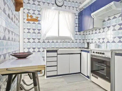 a kitchen with blue and white tiles on the wall at Winahost Barcelona Diagonal in Barcelona
