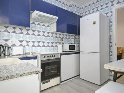 a kitchen with white appliances and blue tiles at Winahost Barcelona Diagonal in Barcelona