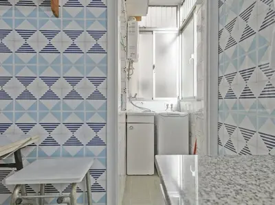 a bathroom with blue and white tiles on the wall at Winahost Barcelona Diagonal in Barcelona