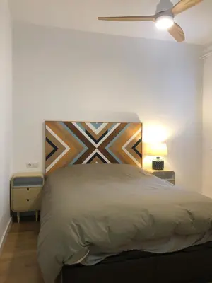 a bedroom with a large bed with a wooden headboard at Charming modern flat in Barcelona in Barcelona