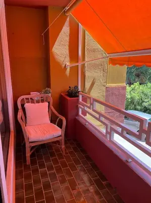 a small balcony with a chair and a window at Cozy apartment close to the beach for 2 persons in Gavà