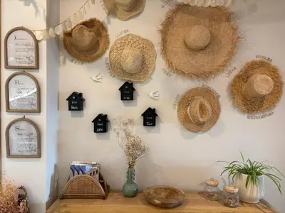 a living room with a bench and straw hats on the wall at Montroig 5 hotel boutique in Sitges