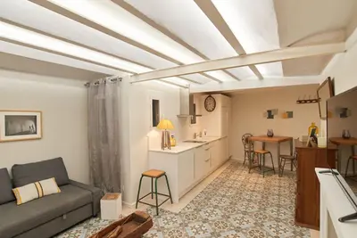 a living room with a couch and a kitchen at Acogedor apartamento en la Sagrada Familia in Barcelona