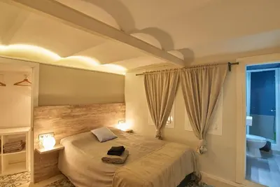 a bedroom with a large bed and a bathroom at Acogedor apartamento en la Sagrada Familia in Barcelona