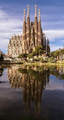 a large building with its reflection in the water at Acogedor apartamento en la Sagrada Familia in Barcelona