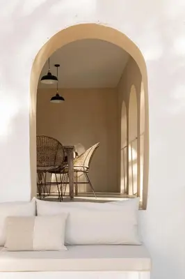 a room with a table and a chair under an archway at Mas Grimosach - Masía en finca y bodega ecológica - Adults Only in Sant Pau dʼOrdal