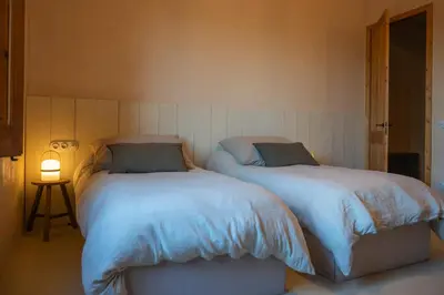 two beds sitting next to each other in a bedroom at Mas Grimosach - Masía en finca y bodega ecológica - Adults Only in Sant Pau dʼOrdal