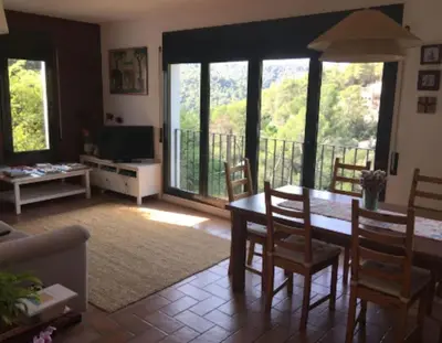 a living room with a table and chairs and a television at Tranquilidad cerca de Barcelona in Molins de Rei