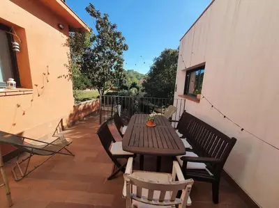 a wooden table and chairs on a patio at Tranquilidad cerca de Barcelona in Molins de Rei