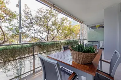 a balcony with a table and chairs and a large window at CCIB Forum Deluxe Apartment in Sant Adria de Besos