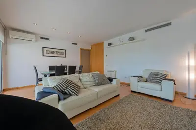a living room with two white couches and a table at CCIB Forum Deluxe Apartment in Sant Adria de Besos