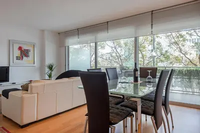 a dining room with a table and a couch at CCIB Forum Deluxe Apartment in Sant Adria de Besos