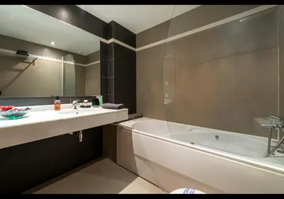 a bathroom with a tub and a sink and a bath tub at CCIB Forum Deluxe Apartment in Sant Adria de Besos