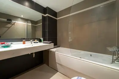 a bathroom with a tub and a sink and a bath tub at CCIB Forum Deluxe Apartment in Sant Adria de Besos