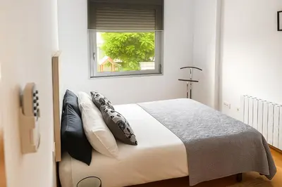 a bedroom with a bed with pillows and a window at CCIB Forum Deluxe Apartment in Sant Adria de Besos