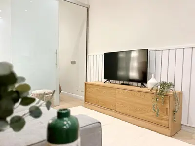 a living room with a flat screen tv on a entertainment center at Eixample Apart Sagrada Familia 52 in Barcelona
