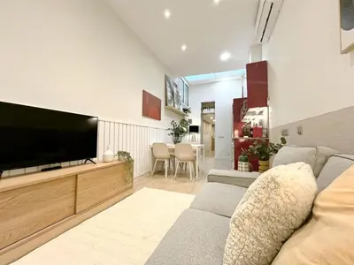 a living room with a couch and a flat screen tv at Eixample Apart Sagrada Familia 52 in Barcelona