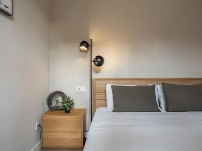 a bedroom with a white bed and a night stand at Sagrada Familia's View 3B1 5Bath in Barcelona