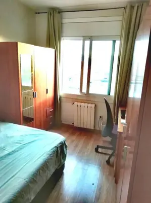 a bedroom with a bed and a desk and windows at Habitación doble exterior en piso compartido in Sant Cugat del Vallès