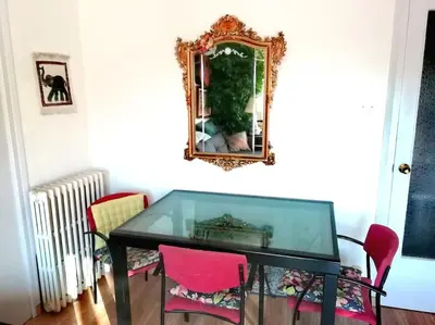 a glass table with pink chairs and a mirror at Habitación doble exterior en piso compartido in Sant Cugat del Vallès