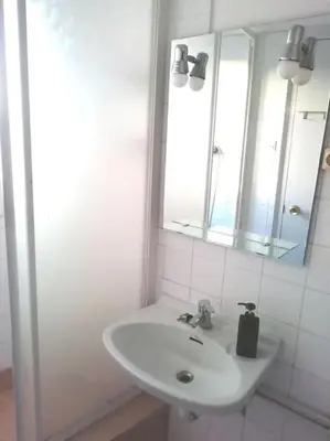 a white bathroom with a sink and a mirror at Habitación doble exterior en piso compartido in Sant Cugat del Vallès