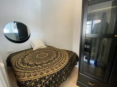 a kitchen with white cabinets and a black stove top oven at Double room with inside window in shared apartment in Barcelona