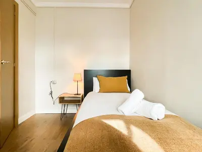 a bedroom with a large bed with a yellow pillow at Boutique Casanova in Barcelona