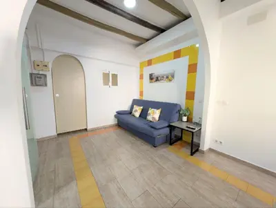 a living room with a blue couch and a table at Zona Camp Nou 15 minutos centro en metro in Hospitalet de Llobregat