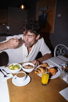 a man sitting at a table eating food with a spoon at Axel TWO Barcelona 4 Sup - Adults Only in Barcelona