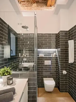 a bathroom with a toilet and a glass shower at Pau Claris - Design apt next to Paseo de Gracia in Barcelona