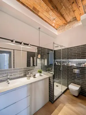 a bathroom with two sinks and a toilet and a shower at Pau Claris - Design apt next to Paseo de Gracia in Barcelona