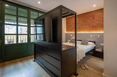 a bedroom with a bed and a dresser with a mirror at Ola Living Batlló in Barcelona