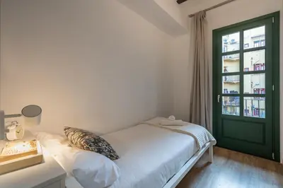 a bedroom with a bed and a green door at Ola Living Batlló in Barcelona