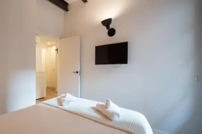 a bedroom with a bed with a tv on the wall at Ola Living Batlló in Barcelona