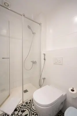 a white bathroom with a shower and a toilet at Ola Living Batlló in Barcelona