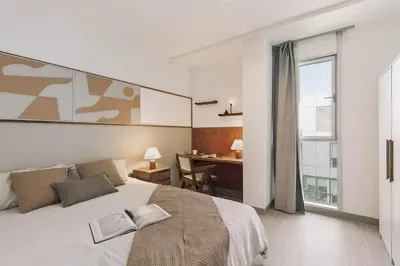 a bedroom with a large bed with a wooden headboard at Sole - 2 bedrooms in Poblenou in Barcelona